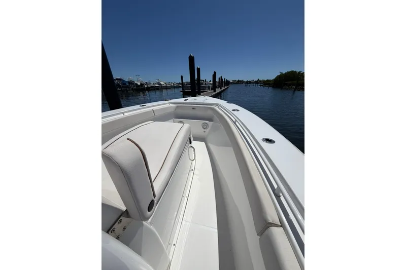 Slide: The Image of 2021 Sea Hunt Gamefish 27 Coffin Box boat docked, showcasing sleek seating and spacious deck. - 19