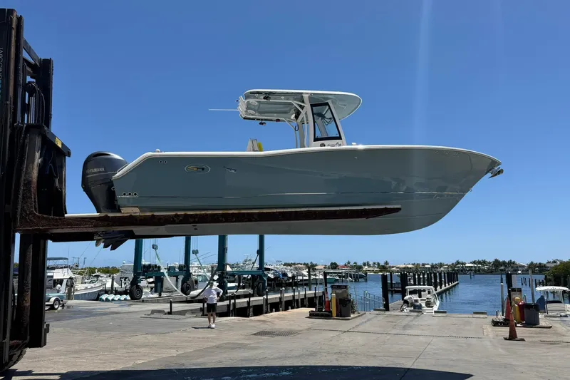 Slide: The Image of 2021 Sea Hunt Gamefish 27 Coffin Box boat lifted at marina dock. - 2