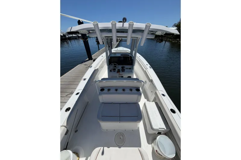 Slide: The Image of 2021 Sea Hunt Gamefish 27 Coffin Box boat docked, showcasing spacious deck and seating. - 9