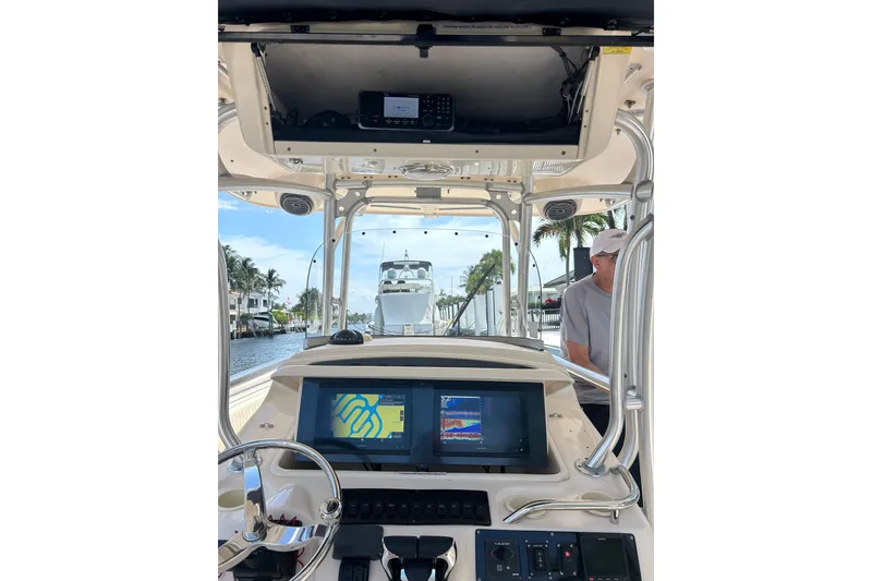 Slide: The Image of 2006 Grady-White Bimini 306 boat dashboard with navigation screens and steering wheel. - 13