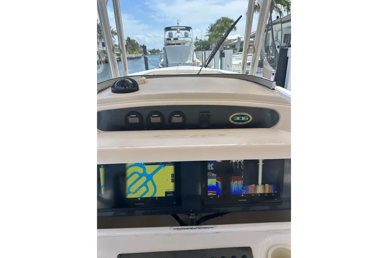 Slide: The Image of 2006 Grady-White Bimini 306 boat dashboard with navigation screens and compass. - 15