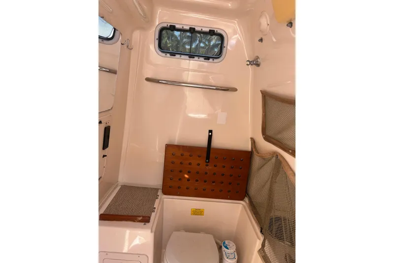Slide: The Image of Interior of a 2006 Grady-White Bimini 306 boat cabin with storage and window. - 19