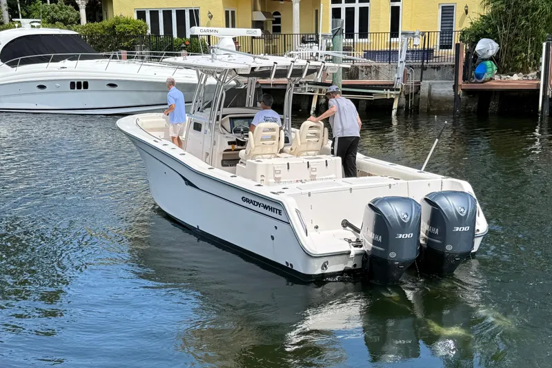 Slide: The Image of 2006 Grady-White Bimini 306 boat with dual Yamaha engines on a calm waterway. - 4