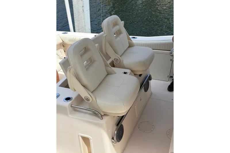 Slide: The Image of 2006 Grady-White Bimini 306 boat seats, cream leather, on deck by water. - 6