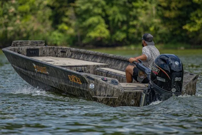 Slide: The Image of 2026 Excel 183 Tomahawk boat navigating a scenic lake with lush greenery. - 3