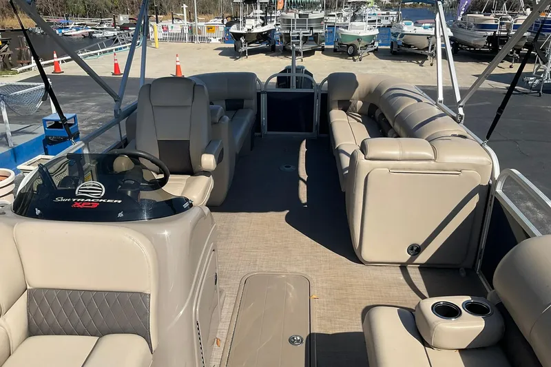 Slide: The Image of 2020 Sun Tracker Party Barge 22 XP3 interior with beige seating and steering console. - 12