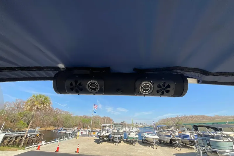Slide: The Image of 2020 Sun Tracker Party Barge 22 XP3 with speakers, docked at a marina under clear skies. - 25