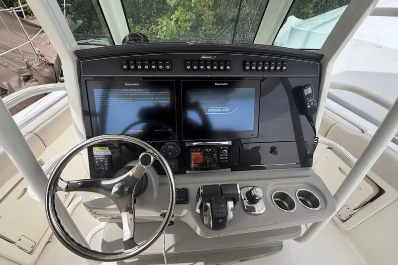 Slide: The Image of Control panel of a 2016 Boston Whaler 330 Outrage with dual screens and steering wheel. - 16