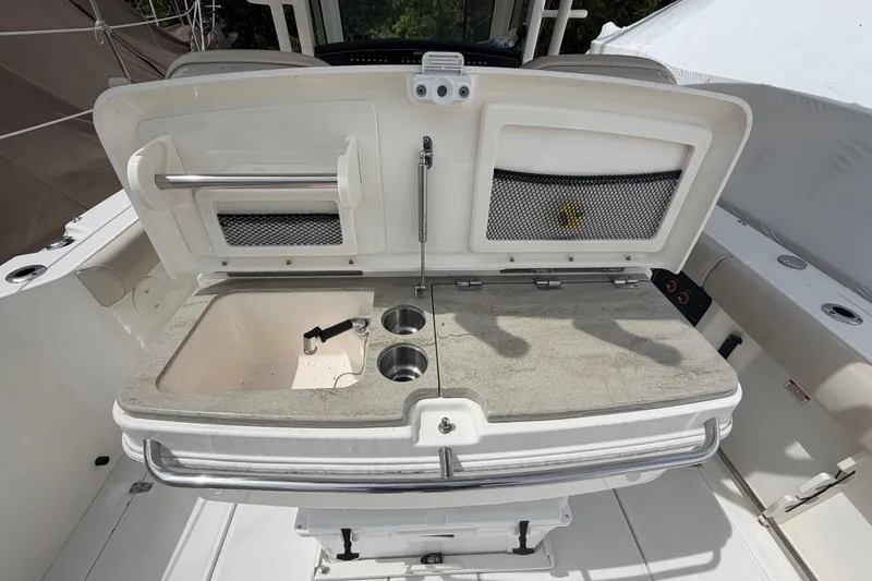 Slide: The Image of Boston Whaler 330 Outrage 2016 boat sink and storage area with cup holders. - 33