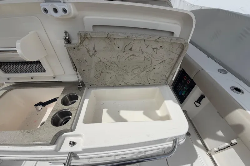 Slide: The Image of Boston Whaler 330 Outrage 2016 boat interior with open storage compartment and sink area. - 35