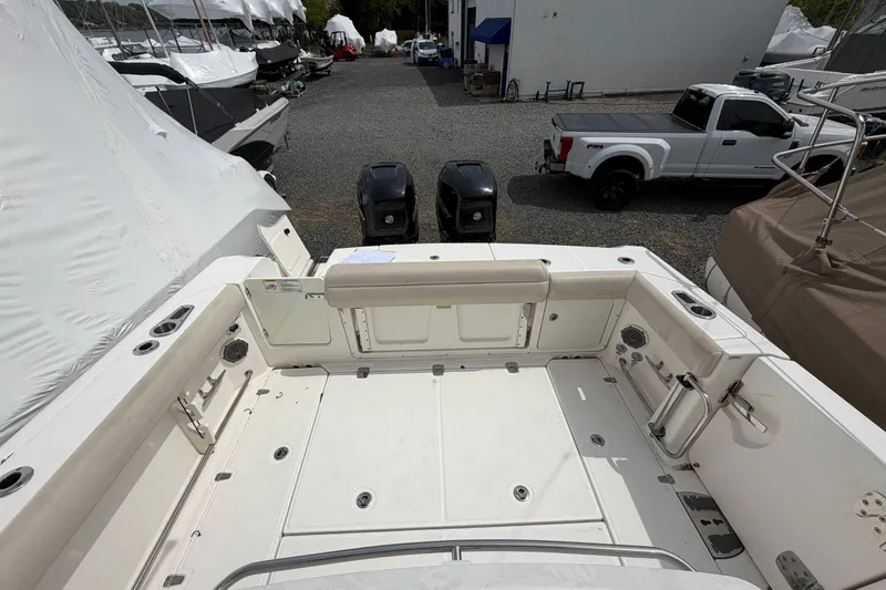 Slide: The Image of 2016 Boston Whaler 330 Outrage boat deck with twin engines, parked near covered boats. - 37