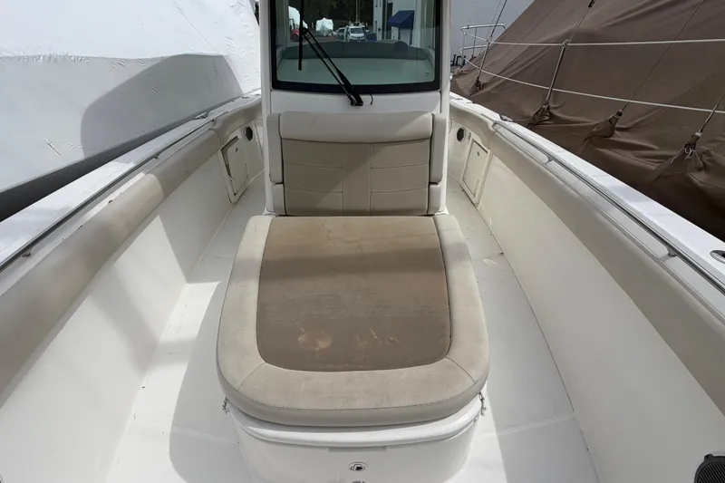 Slide: The Image of 2016 Boston Whaler 330 Outrage boat interior with cushioned seating area. - 4