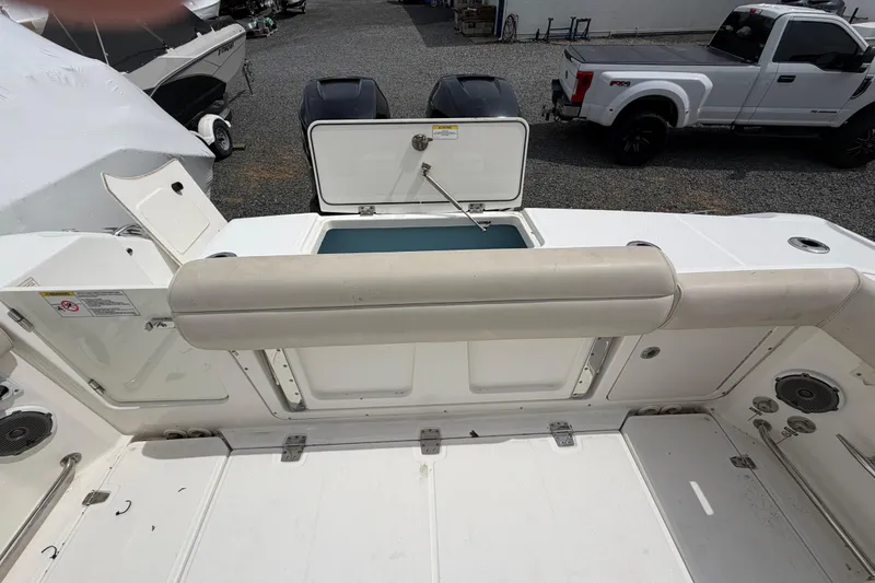 Slide: The Image of 2016 Boston Whaler 330 Outrage boat interior with open storage compartment and twin engines. - 41