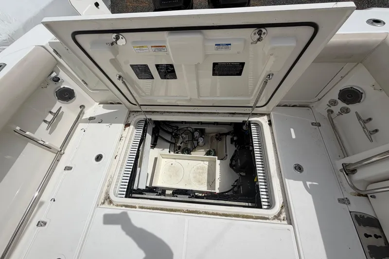 Slide: The Image of Open hatch on a 2016 Boston Whaler 330 Outrage, revealing internal components and storage. - 43