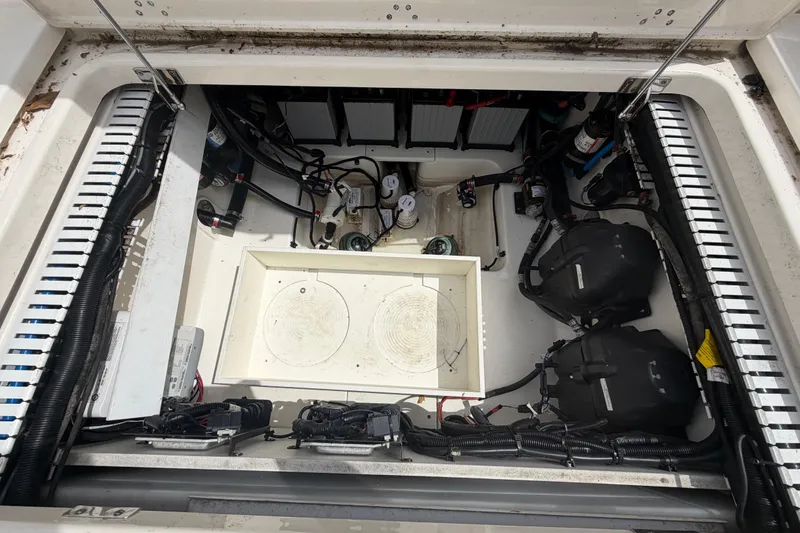 Slide: The Image of Engine compartment of a 2016 Boston Whaler 330 Outrage, showcasing wiring and components. - 44
