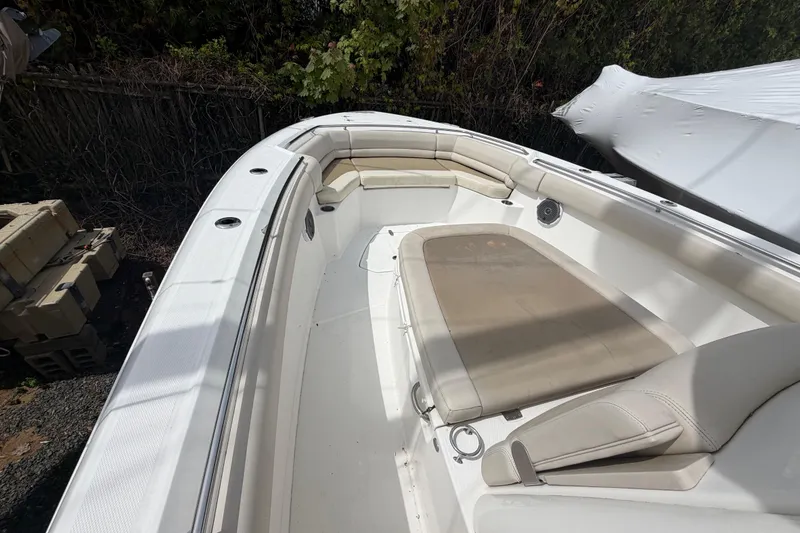 Slide: The Image of 2016 Boston Whaler 330 Outrage boat interior with cushioned seating and clean deck. - 9