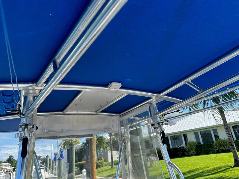 Slide: The Image of 2007 Contender 33 Tournament boat with blue canopy and metal frame. - 13
