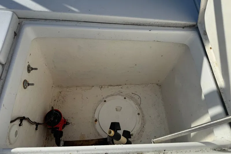Slide: The Image of Open storage compartment in 1986 Dolphin 18 Skiff boat, showing interior details. - 7