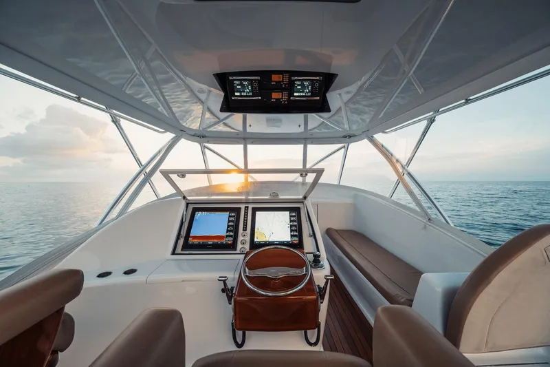 Slide: The Image of Helm of 2016 F&S Express boat with navigation screens, steering wheel, and ocean view. - 12