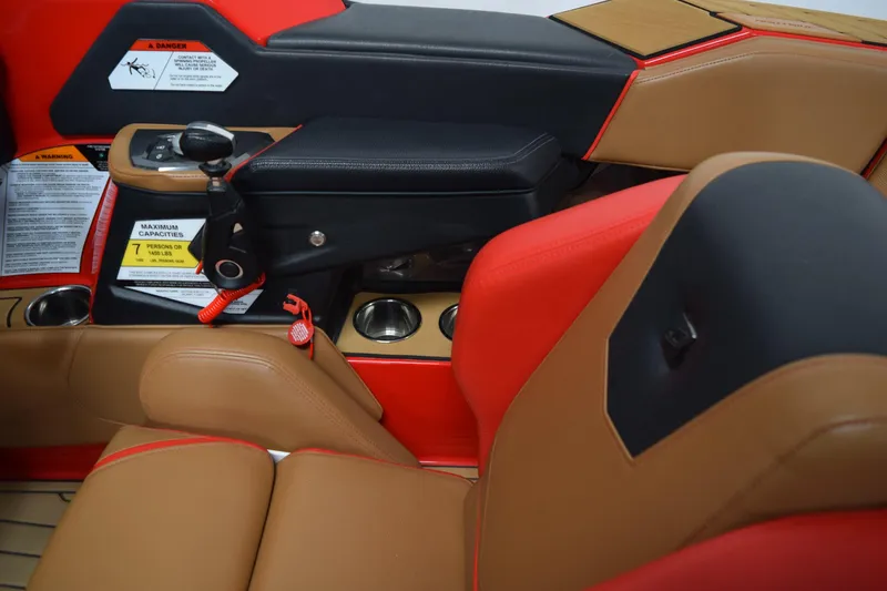 Slide: The Image of 2024 Nautique Ski Nautique interior with red and tan seating, cup holders, and control panel. - 12