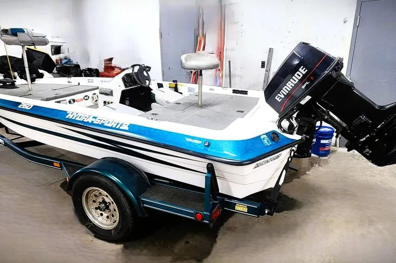 The Image of 1997 Stratos 268V 17' SC Bass Boat with Evinrude motor in a garage setting. - 0