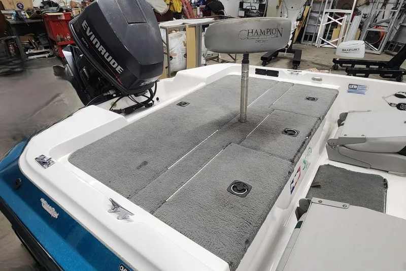 Slide: The Image of 1997 Stratos 268V 17' SC Bass Boat with Evinrude motor in a workshop setting. - 2