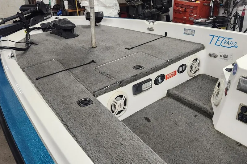 Slide: The Image of 1997 Stratos 268V 17' SC Bass Boat interior with carpeted deck and fishing equipment. - 4