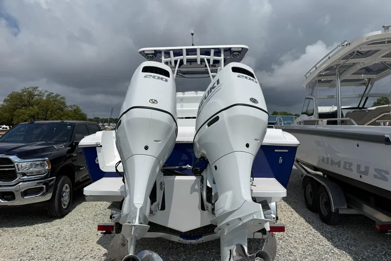 Slide: The Image of 2026 Clearwater 2800 Center Console boat with dual Suzuki 200 engines, parked outdoors. - 2
