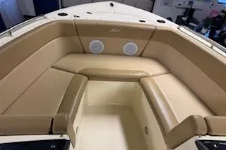 Slide: The Image of 2021 Scout 215 Dorado boat interior with tan seating and built-in speakers. - 18