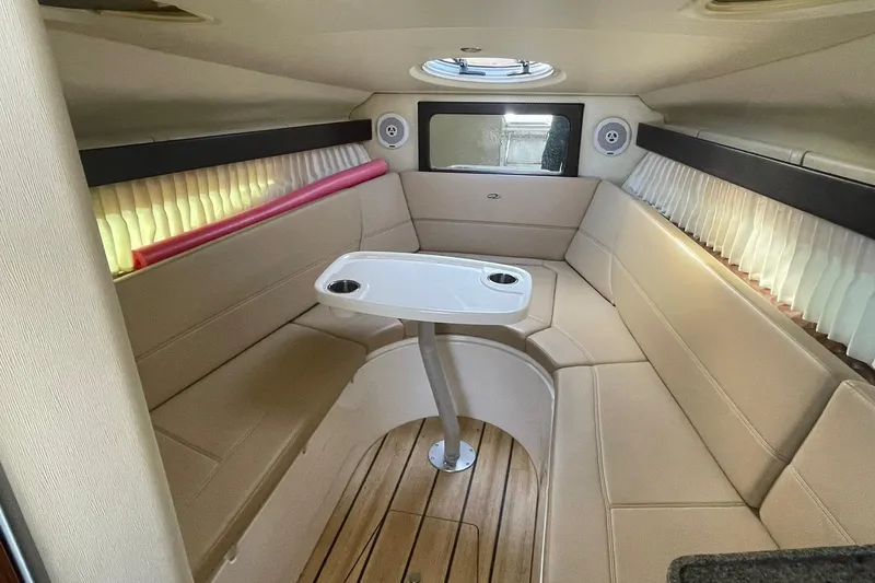 Slide: The Image of Interior of 2013 Regal 28 Express boat with beige seating and a central table. - 12