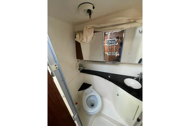 Slide: The Image of Bathroom interior of 2013 Regal 28 Express boat with sink, toilet, and mirror. - 14