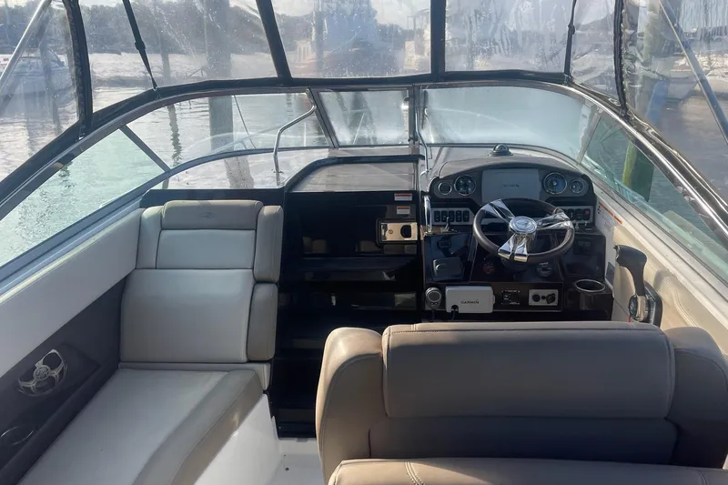 Slide: The Image of Interior view of a 2013 Regal 28 Express boat cockpit with steering wheel and seating. - 4