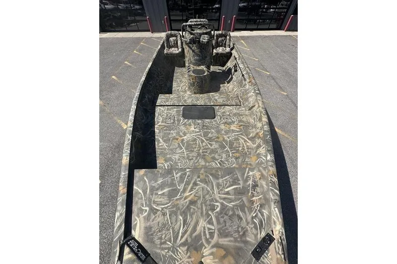 Slide: The Image of 2026 War Eagle 2170 Blackhawk boat with camouflage design, parked outdoors. - 3