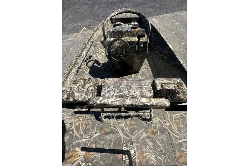 Slide: The Image of Camouflage interior of 2026 War Eagle 2170 Blackhawk boat with steering console and seating. - 9