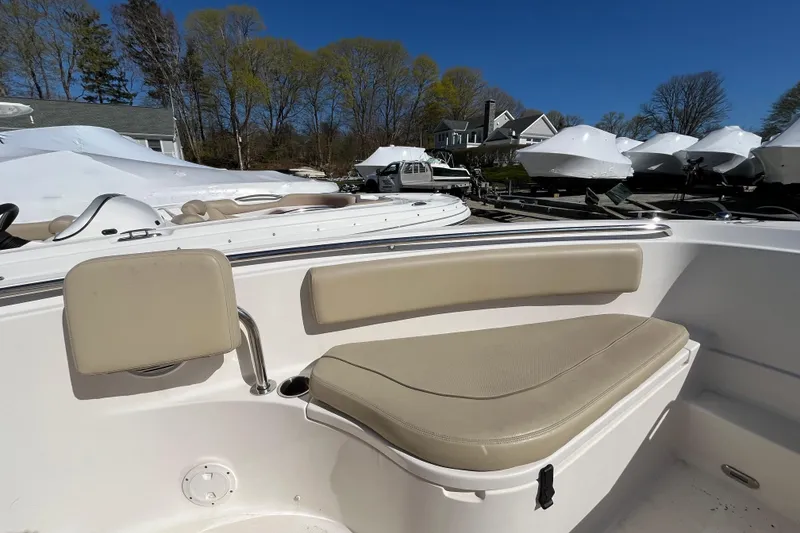 Slide: The Image of 2017 Pursuit C 238 Center Console boat interior with beige seating, parked outdoors. - 10