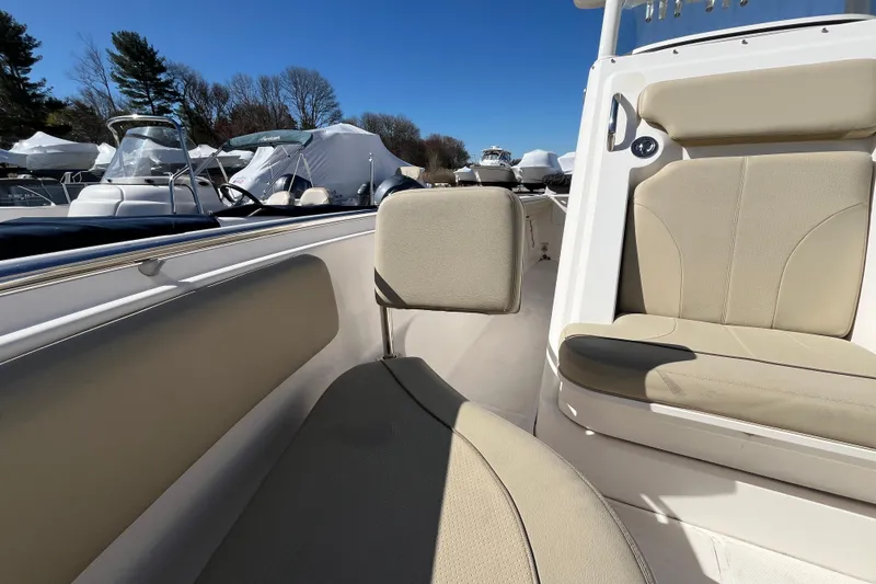 Slide: The Image of 2017 Pursuit C 238 Center Console boat interior with beige seating and clear blue sky. - 11