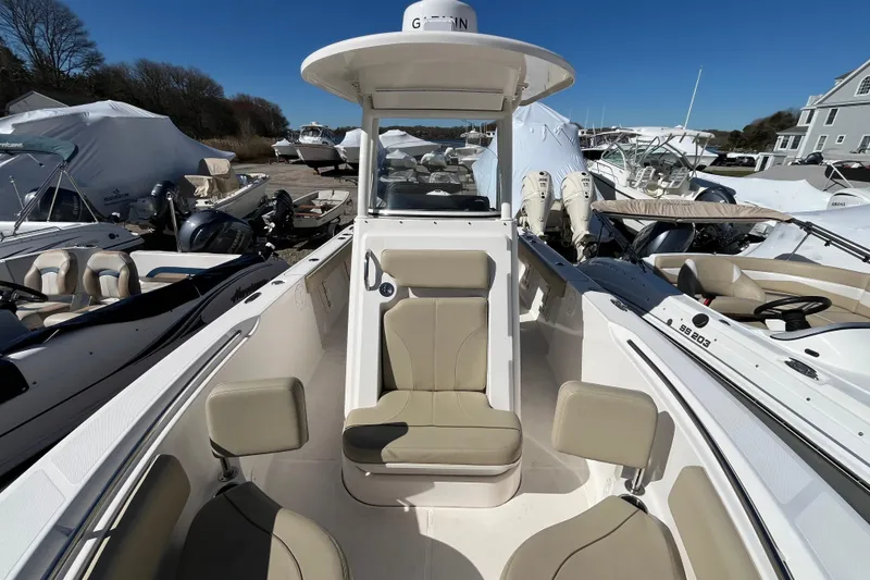 Slide: The Image of 2017 Pursuit C 238 Center Console boat with seating, docked among other boats. - 13