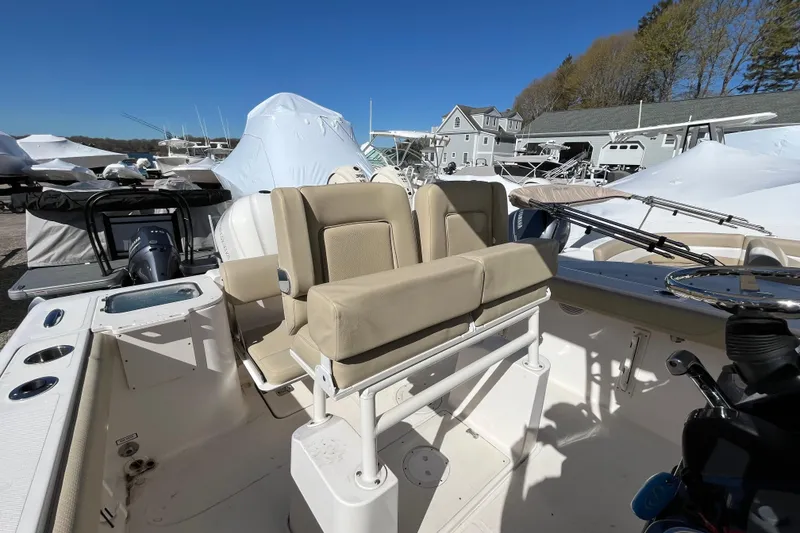 Slide: The Image of 2017 Pursuit C 238 Center Console boat with beige seating, docked outdoors. - 16