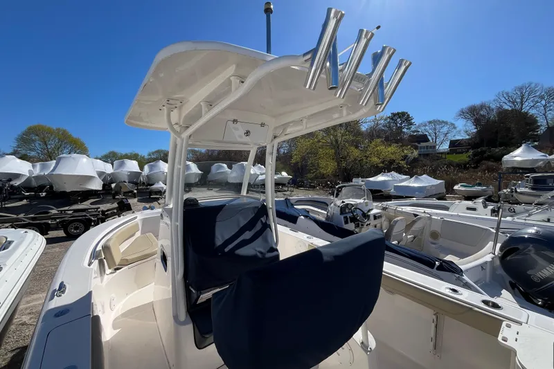 Slide: The Image of 2017 Pursuit C 238 Center Console boat docked, featuring a T-top and rod holders. - 8