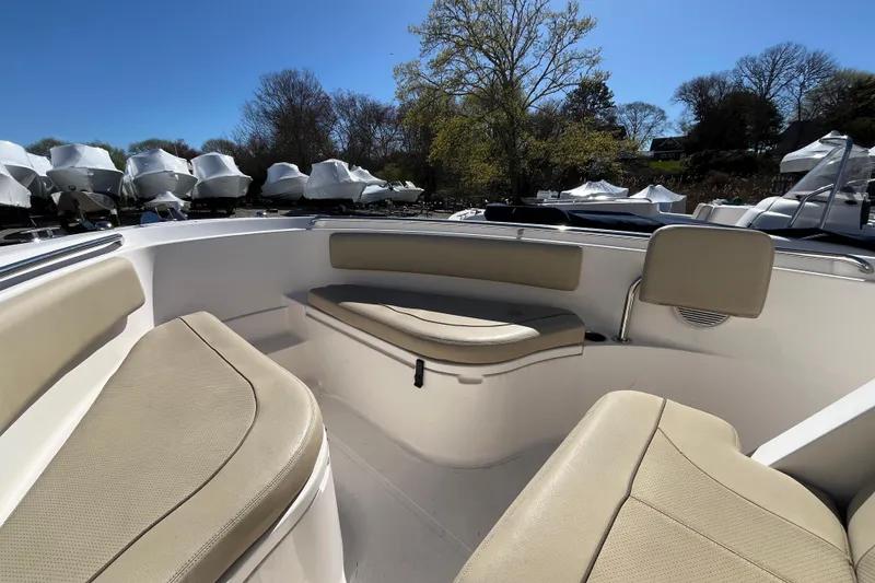 Slide: The Image of 2017 Pursuit C 238 Center Console boat interior with beige seating and clear blue sky. - 9