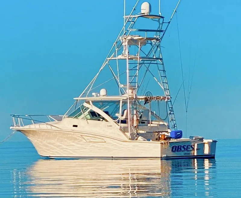 Slide: The Image of 2004 Cabo 40 Express yacht on calm water, featuring a tall tower and sleek design. - 1