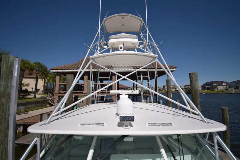 Slide: The Image of 2004 Cabo 40 Express boat docked, showcasing tower and equipment under clear blue sky. - 10