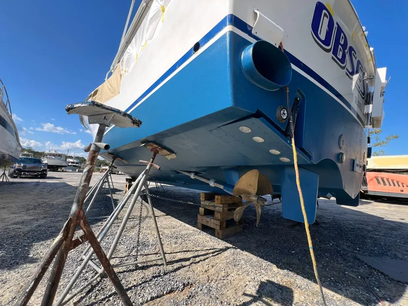 Slide: The Image of 2004 Cabo 40 Express boat on stands, showing hull and propeller, in a boatyard. - 19