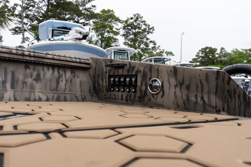 Slide: The Image of 2026 Excel 203 Bay Pro Elite boat interior with control panel and camo design. - 12