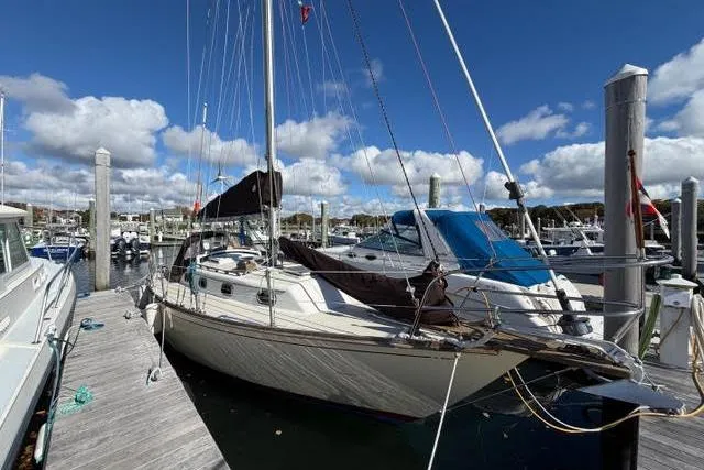 The Image of 1985 Cape Dory Cutter sailboat docked at a marina under a clear blue sky. - 0