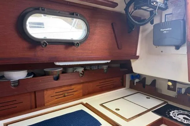 Slide: The Image of 1985 Cape Dory Cutter interior with wooden cabinetry and nautical equipment. - 13