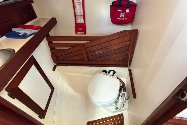 Slide: The Image of 1985 Cape Dory Cutter boat bathroom with toilet, wooden accents, and safety equipment. - 15