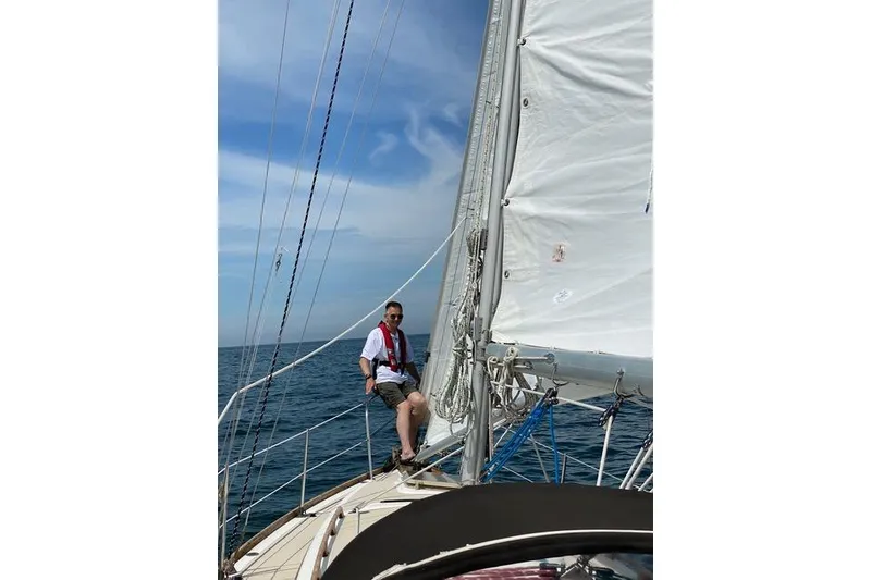 Slide: The Image of Man sailing on a 1985 Cape Dory Cutter under clear skies. - 19