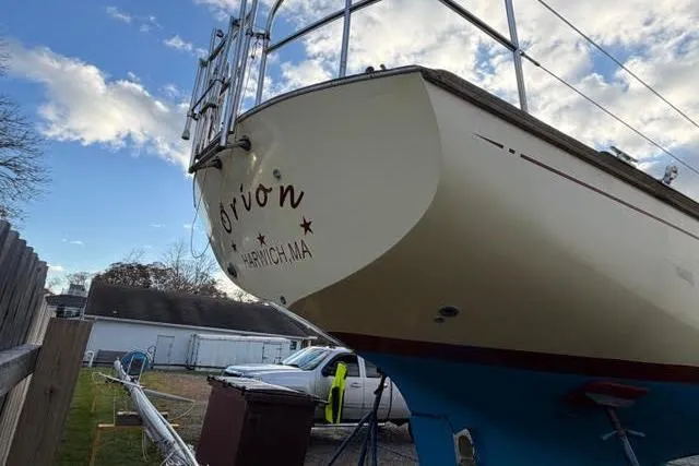 Slide: The Image of 1985 Cape Dory Cutter sailboat on land, with blue hull and clear sky background. - 24