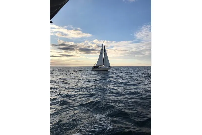 Slide: The Image of 1985 Cape Dory Cutter sailing on open sea under a clear blue sky. - 26